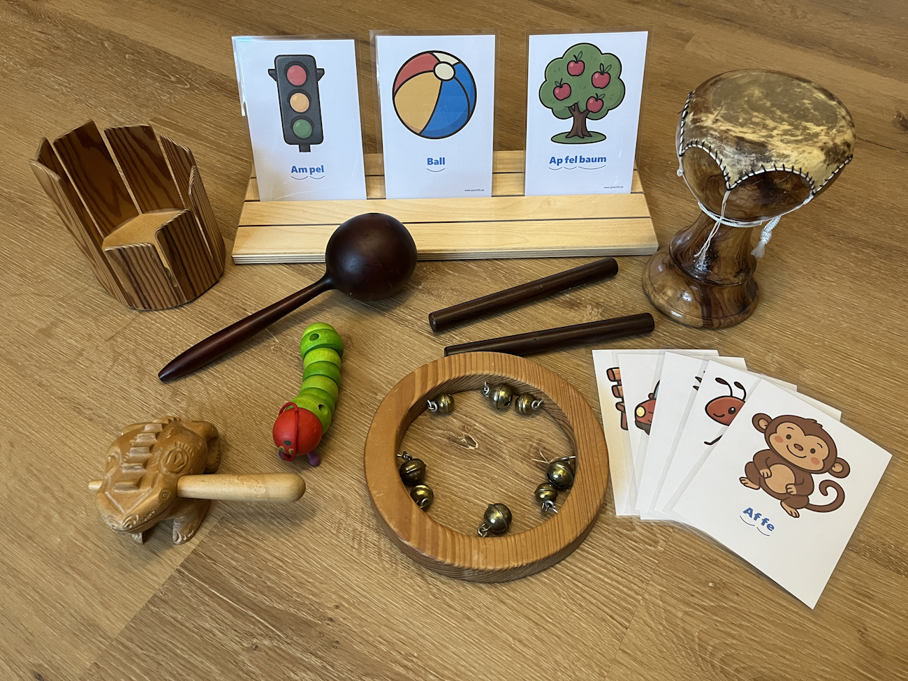 Foto versachiedener Materialien zur Sprachförderung, z.B. Silbenkarten, Bilder, Spielzeug